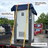 Portable restroom unit on a flatbed trailer with ratchet tie-down straps and plastic corner guards.
